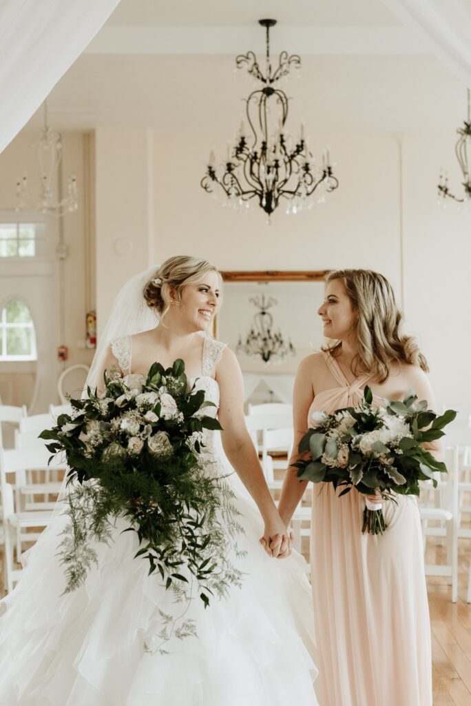 bride and bridesmaid holding hands