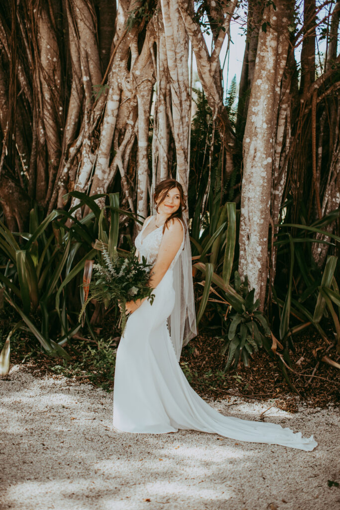 bride surrounded by tropical trees and ferns