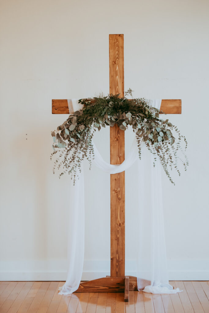 cross with greenery for wedding altar
