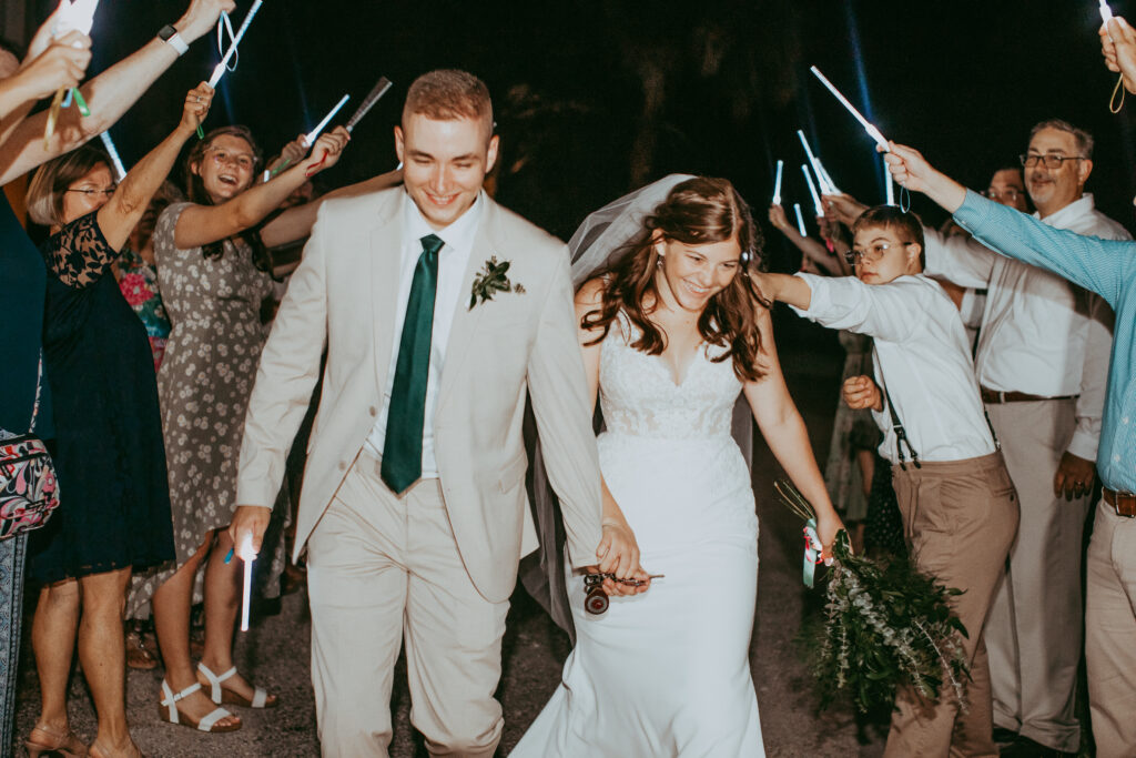bride and groom exit with glow sticks