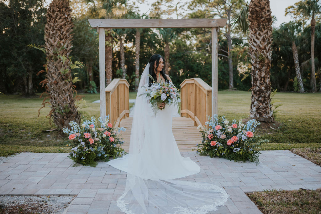 bride holding bridal bouquet with palm trees in the background