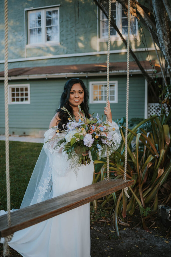 bride on rope swing holding bridal bouquet