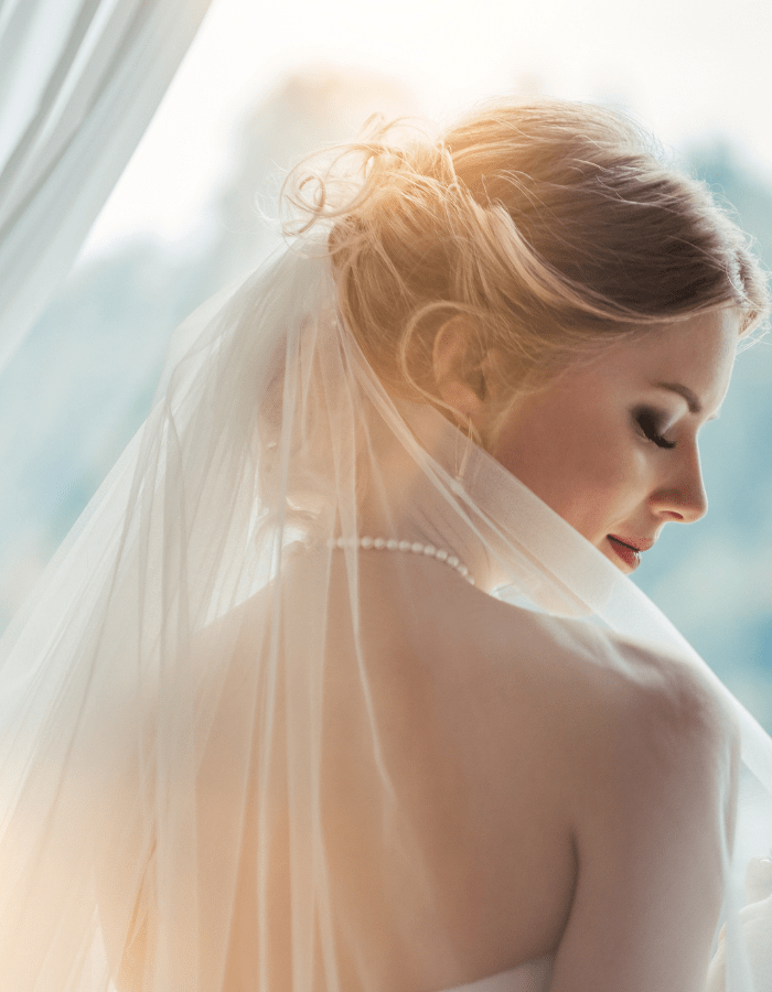 bride looking over her shoulder wearing  veil
